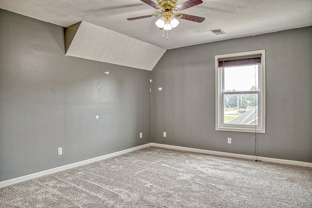 carpeted empty room featuring vaulted ceiling and ceiling fan