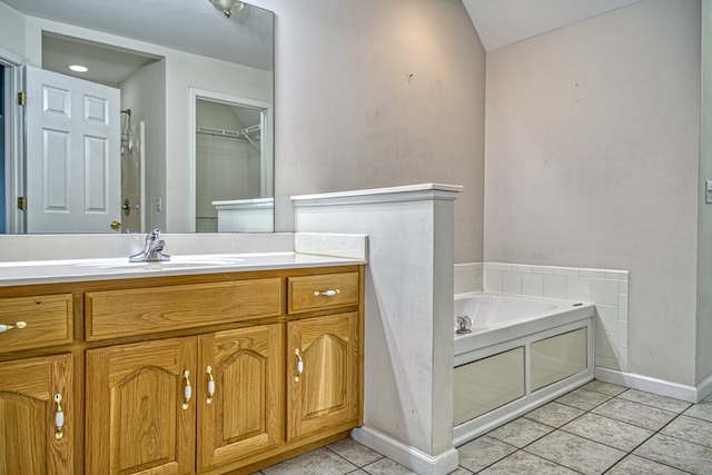 bathroom featuring tile patterned flooring, vanity, and a bath