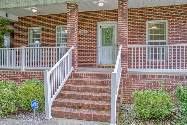 view of exterior entry with a porch