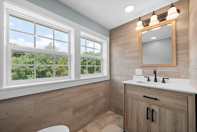 bathroom with vanity and tile walls