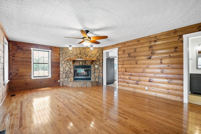 unfurnished living room featuring a textured ceiling, hardwood / wood-style floors, and a fireplace