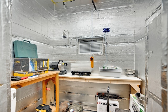 interior space with a workshop area and an AC wall unit