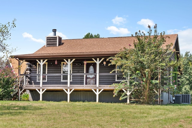 rear view of property featuring a yard, a shingled roof, and a chimney