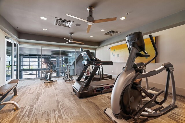 gym featuring wood finished floors, visible vents, baseboards, and ceiling fan