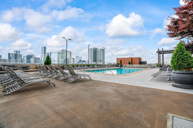 view of swimming pool featuring a patio and a view of city