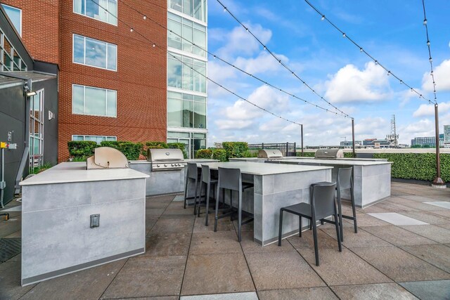 view of patio featuring a grill, exterior bar, and exterior kitchen