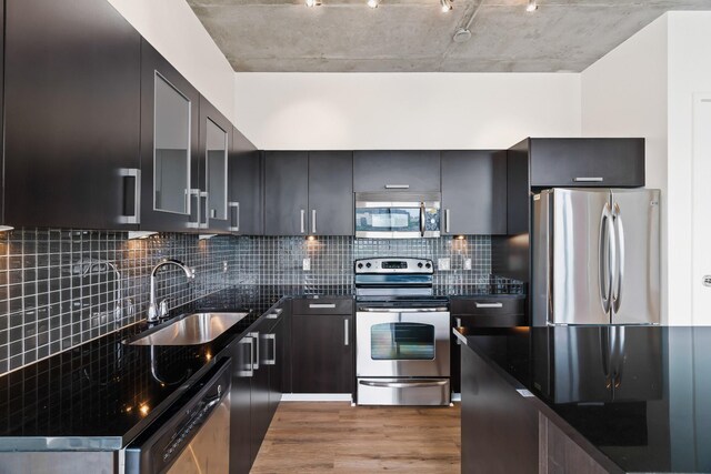 kitchen featuring sink, stainless steel appliances, light hardwood / wood-style flooring, and tasteful backsplash