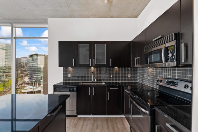 kitchen featuring sink, decorative backsplash, appliances with stainless steel finishes, and light wood-type flooring