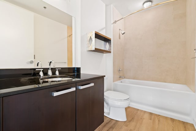 bathroom with vanity, toilet, wood finished floors, and shower / bathtub combination