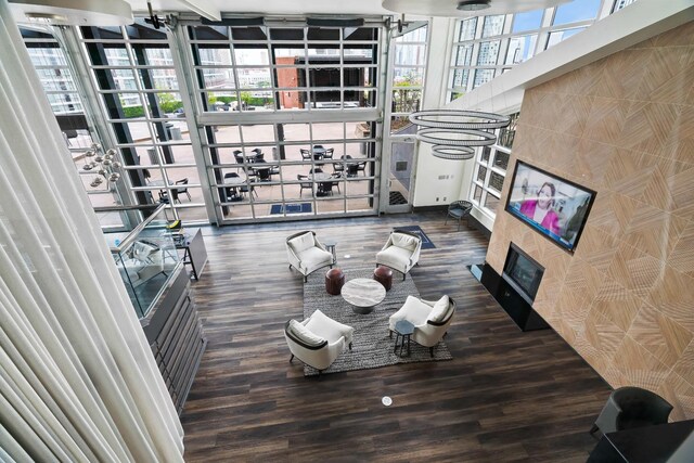 interior space featuring hardwood / wood-style flooring, a high ceiling, and a wall of windows