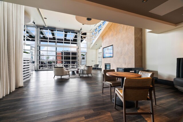 dining area featuring a wall of windows, a chandelier, and wood-type flooring