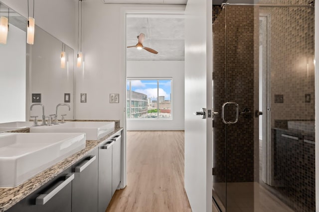 full bath with vanity, wood finished floors, a stall shower, and a ceiling fan