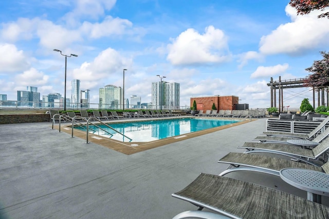community pool featuring a view of city and a patio area
