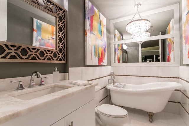 bathroom with toilet, tile patterned floors, a freestanding tub, a chandelier, and tile walls