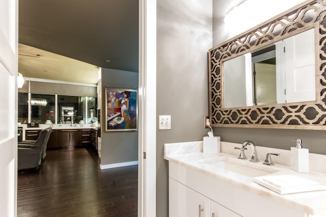 bathroom featuring wood finished floors, vanity, and baseboards