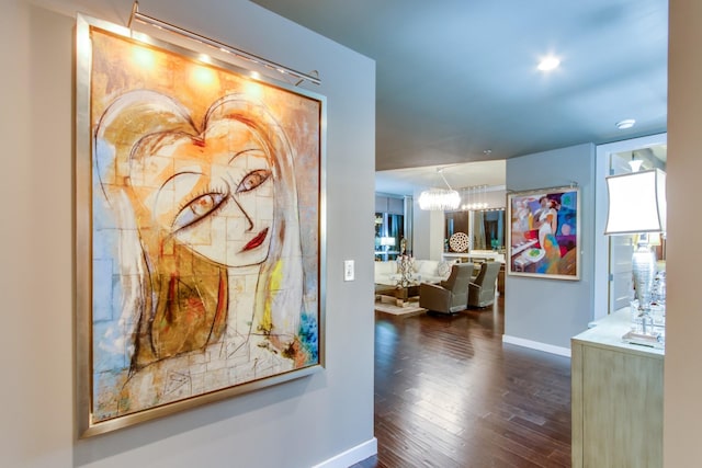 hall featuring dark wood-style flooring and baseboards