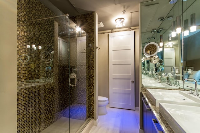 full bathroom featuring toilet, a stall shower, double vanity, and a sink