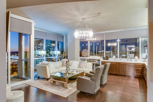 living room with sink, dark wood-type flooring, and a chandelier