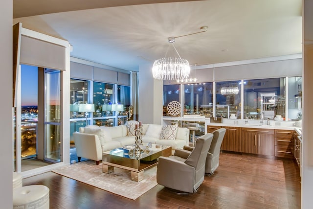 living room with expansive windows, wood finished floors, and an inviting chandelier