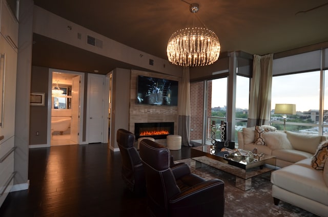 living room with hardwood / wood-style floors, a large fireplace, and an inviting chandelier