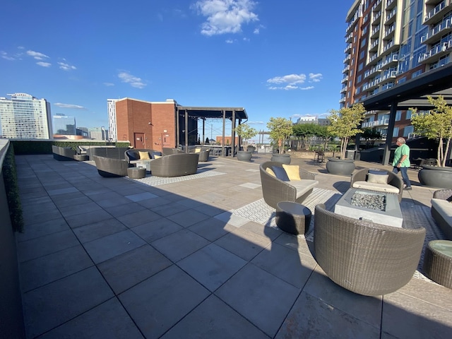 view of patio featuring an outdoor living space with a fire pit and a city view