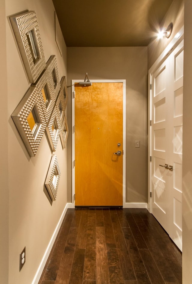 entryway with dark wood-style floors and baseboards