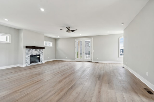 unfurnished living room with light wood-type flooring, french doors, and ceiling fan