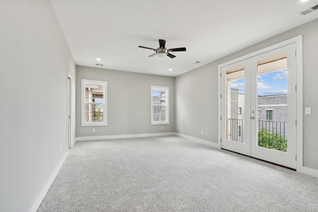 spare room with plenty of natural light, french doors, and light carpet