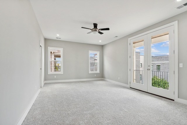 spare room with french doors, carpet flooring, visible vents, and baseboards