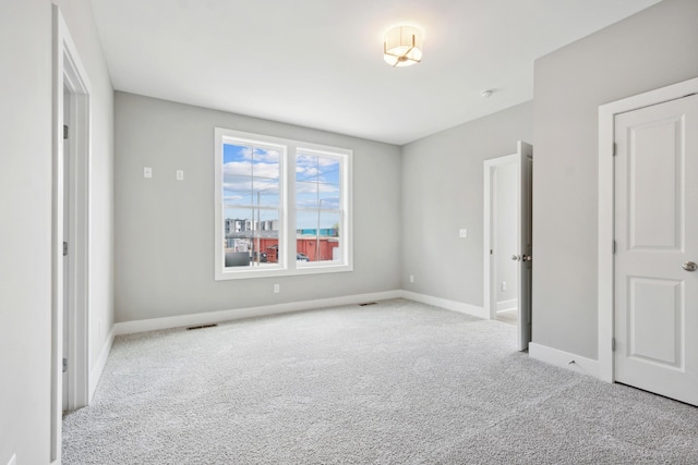 unfurnished bedroom with carpet floors, visible vents, and baseboards