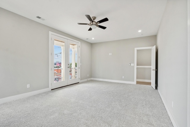 carpeted empty room with a ceiling fan, french doors, visible vents, and baseboards