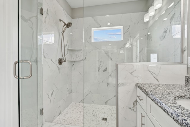 bathroom featuring tile walls, vanity, and a shower with shower door