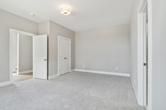 unfurnished bedroom with baseboards and light colored carpet