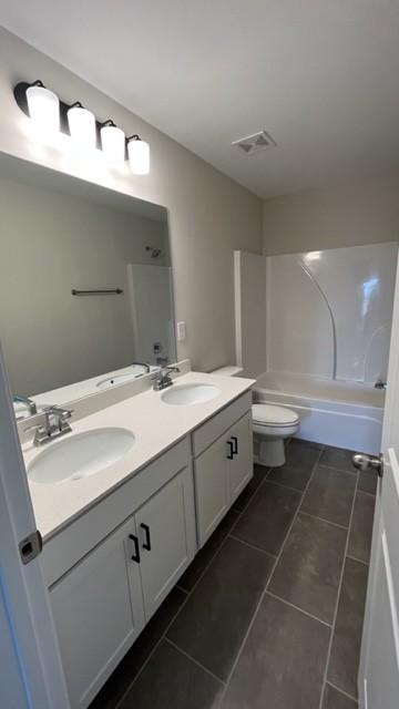 full bathroom with tile patterned floors,  shower combination, vanity, and toilet