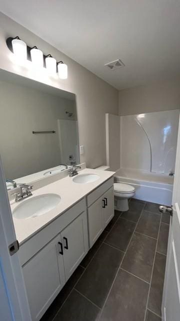 full bath with visible vents, a sink, toilet, and double vanity