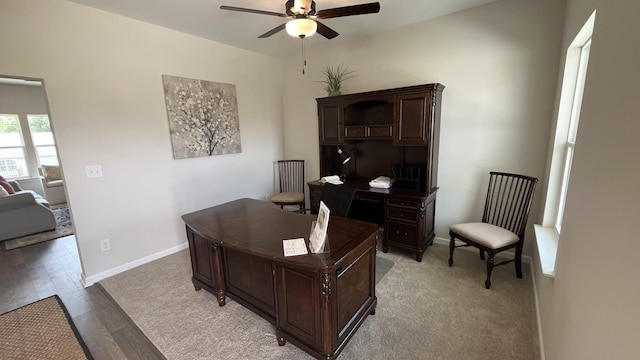 office with a ceiling fan, light wood finished floors, and baseboards