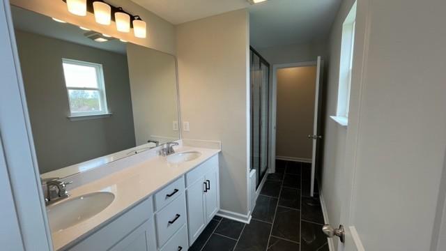 bathroom with an enclosed shower, vanity, and tile patterned floors