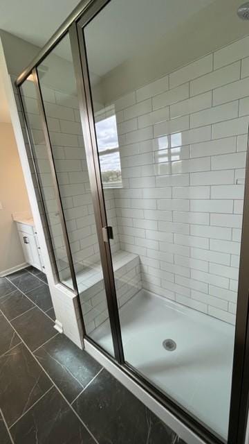 bathroom featuring a stall shower, marble finish floor, and baseboards