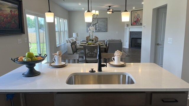 kitchen with a kitchen island with sink, hanging light fixtures, and ceiling fan