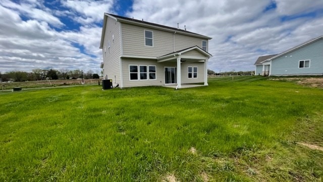 back of house featuring cooling unit and a yard