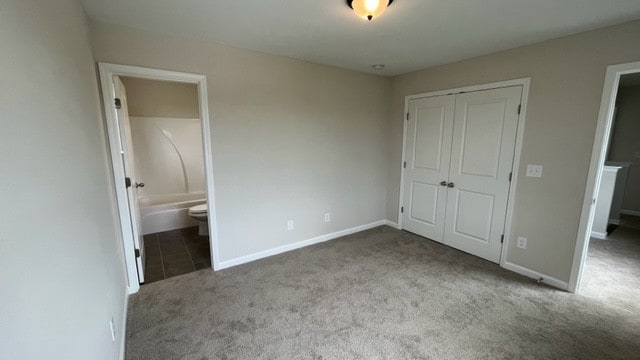 unfurnished bedroom featuring tile patterned flooring, a closet, and connected bathroom