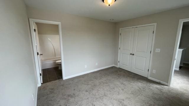 unfurnished bedroom with light carpet, ensuite bath, baseboards, and a closet