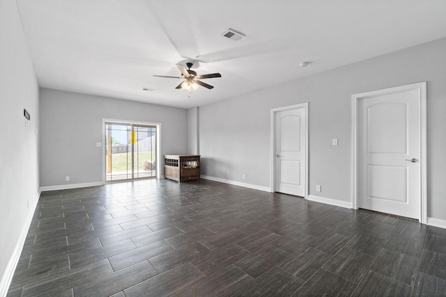 empty room with baseboards, wood tiled floor, visible vents, and a ceiling fan