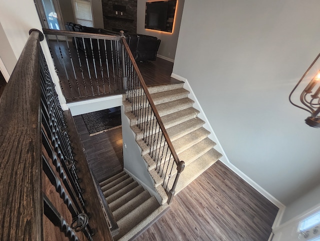 staircase featuring hardwood / wood-style floors and a high ceiling