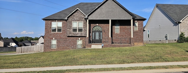 view of front of property with fence, a front lawn, and brick siding