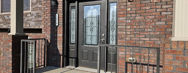 view of exterior entry with brick siding