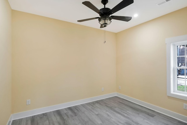 empty room with recessed lighting, wood finished floors, visible vents, and baseboards