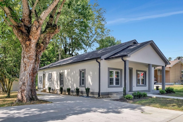 view of front of property featuring a porch, concrete driveway, and stucco siding