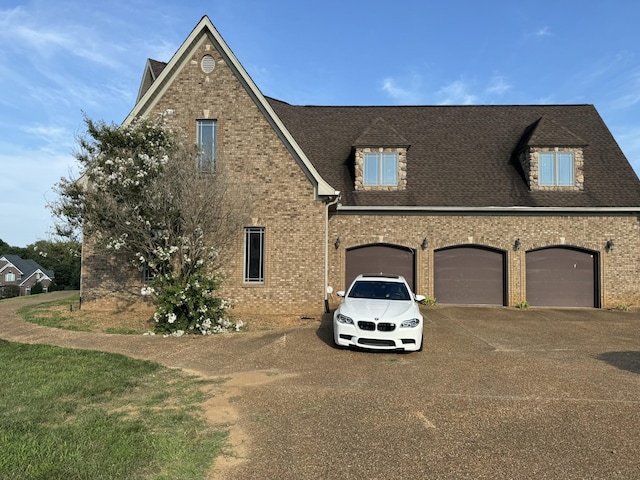 view of front of property with driveway, brick siding, and a shingled roof