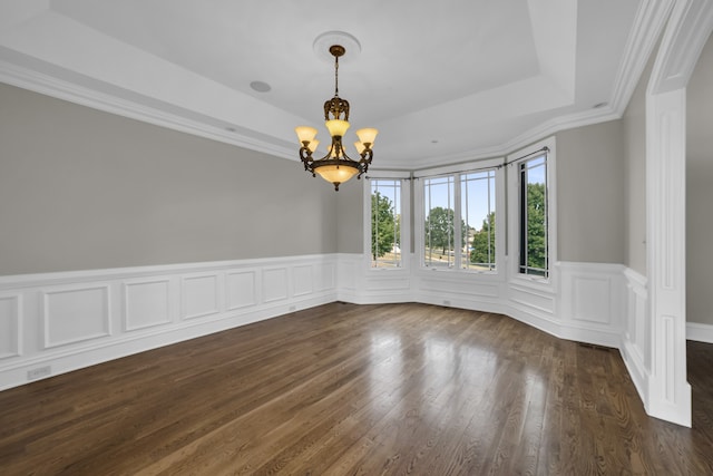 spare room featuring a tray ceiling, dark hardwood / wood-style flooring, ornamental molding, and an inviting chandelier